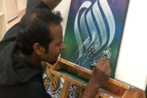 الخطاط الهندي كريم غرافي برع في الرسم بالخط العربي (الجزيرة)
